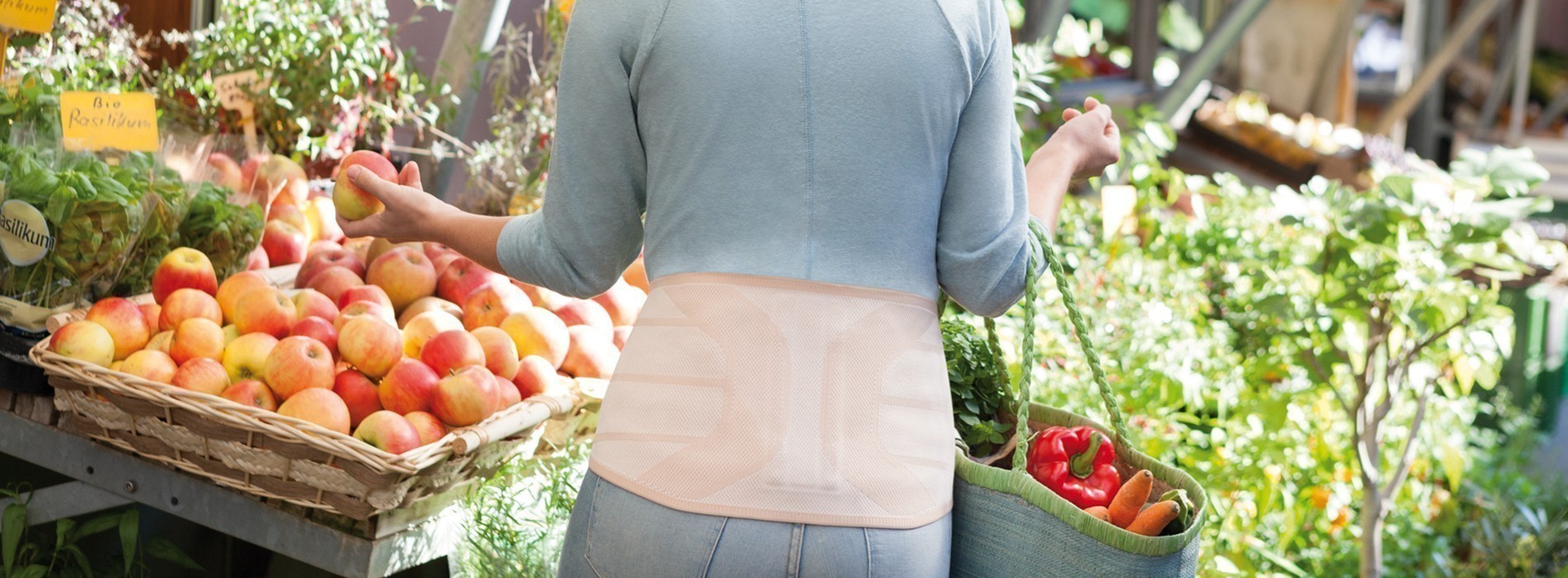 Mujer en el supermercado con una ortesis de espalda