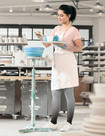 Une femme examine des plats en céramique et porte des bas de compression Juzo Inspiration dans la couleur Dip Dye Myrtille