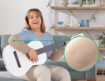 Kvinde med Juzo Expert med funktionszone albue sidder på sofaen og spiller guitar