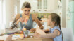 A mother and daughter doing crafts. The daughter is wearing a scar compression garment on her arm