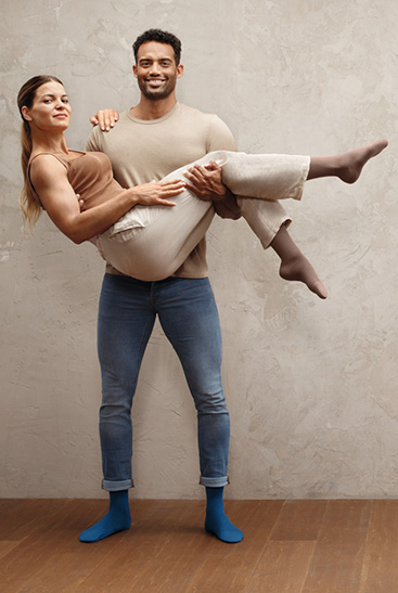 2. Juzo Intenso Mężczyzna niosący kobietę w ramionach, oboje w pończochach Juzo Intenso