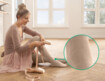 Kvinde i ballerinaoutfit med Juzo Expert med funktionszone vrist sidder på gulvet og tager tåspidssko på