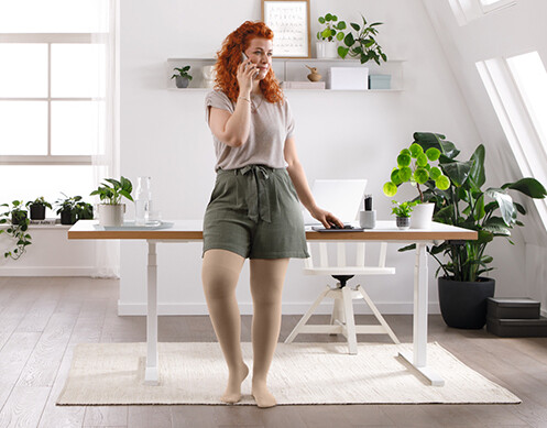 Een vrouw staat in haar woonkamer te bellen