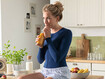 Kvinna med thoraxprodukt dricker en smoothie