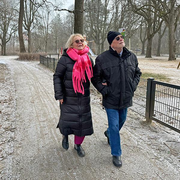 Eine Dame geht mir ihrem Mann im Park spazieren