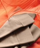 13. Lifestyle Bild Juzo Inspiration Juzo Inspiration Strümpfe liegen auf einem Orangenen Tüllkleid