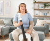 Femme avec guitare et zone fonctionnelle Coude Juzo Expert
