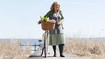 A woman on a footbridge. She has lymphoedema on one leg and is wearing compression stockings.