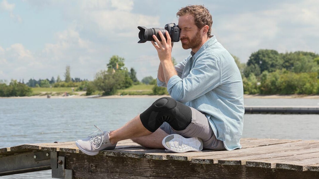 A photographer is sitting on a jetty. He is wearing a Juzo knee brace A photographer is sitting on a jetty. He is wearing a Juzo knee brace