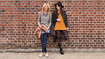 Two women lean against a wall and wear compression stockings with a batik pattern