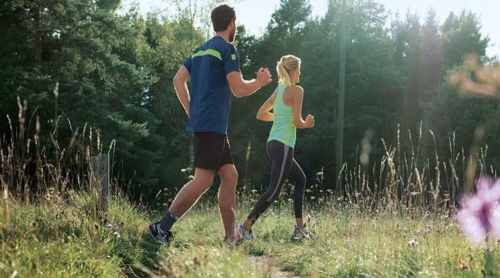 Pain in the ankle joint Man and woman jogging