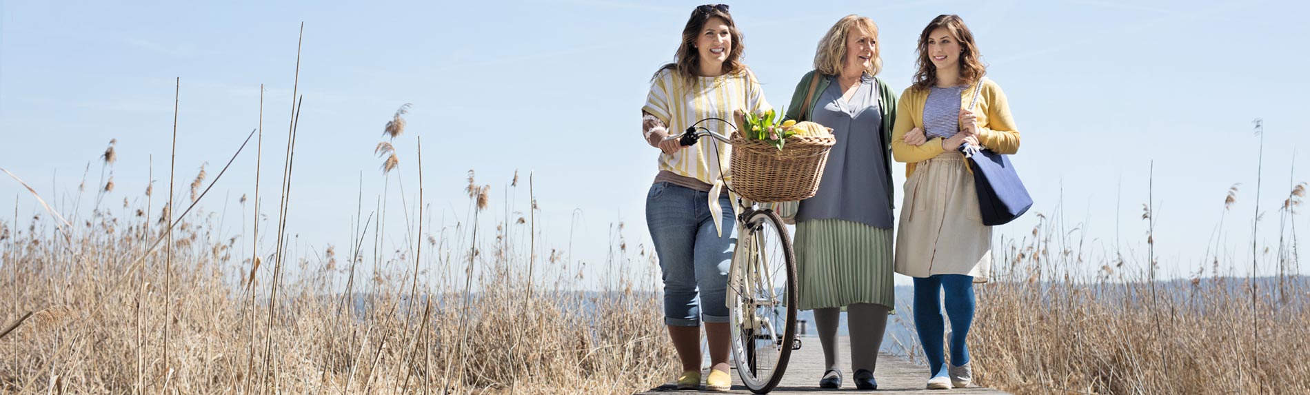Women with bicycles by a pier