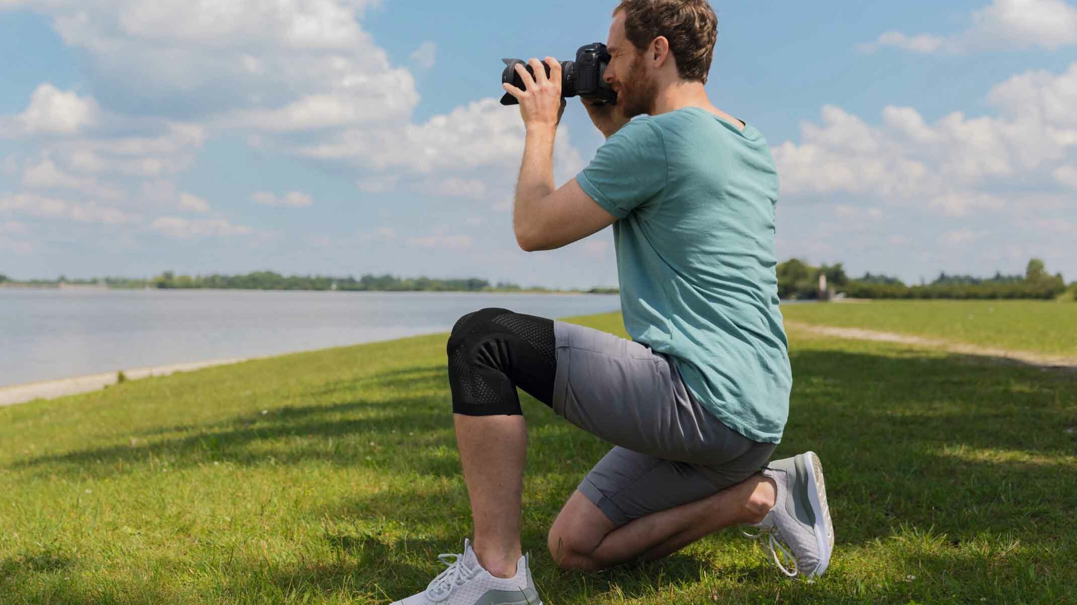 Infoseite zu Gonarthrose Ein Fotograf trägt eine Juzo Kniebandage