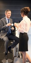 Gesprek aan de bar waarbij de man zit en de vrouw staat
