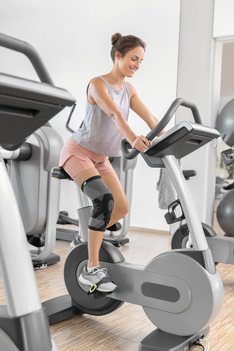 A woman in a gym wearing a knee brace A woman in a gym wearing a knee brace